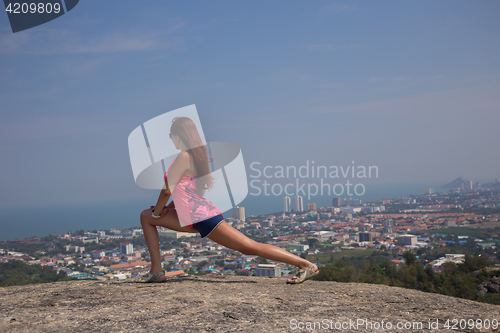 Image of Young brunette doing stretching exercises