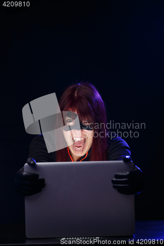 Image of Screaming girl hacker at night