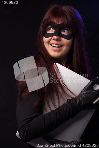 Image of Hacker in mask holds laptop