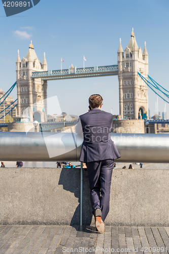 Image of British businessman talking on mobile phone outdoor in London city, UK.