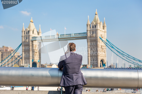 Image of British businessman talking on mobile phone outdoor in London city, UK.