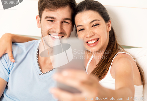 Image of Couple on bed making selfies