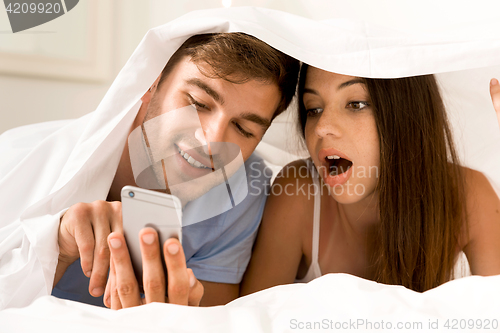 Image of Using a cellphone under the sheets