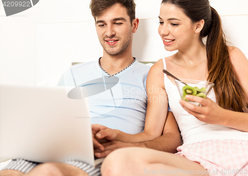 Image of Couple on bed with a laptop