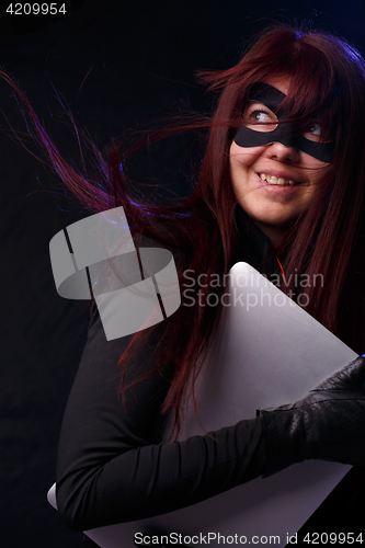 Image of Brunette in mask holds laptop