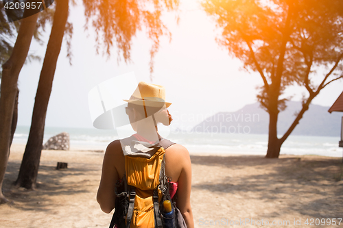 Image of Woman in hat stands back