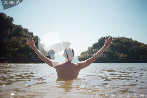 Image of Man stands in sea during day