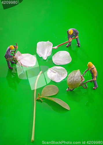 Image of Miniature figures working to create spring flower