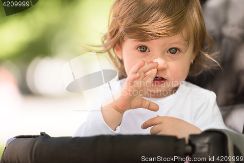 Image of baby girl sitting in the pram