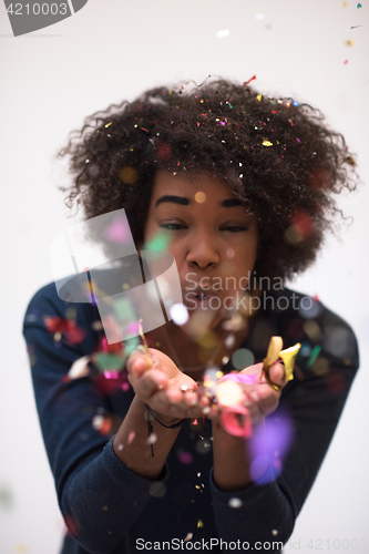 Image of African American woman blowing confetti in the air
