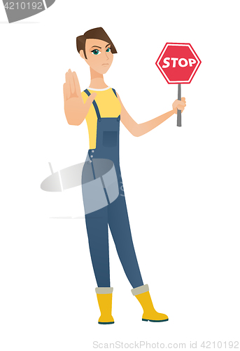 Image of Caucasian farmer holding stop road sign.