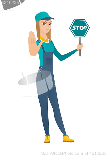 Image of Caucasian mechanic holding stop road sign.