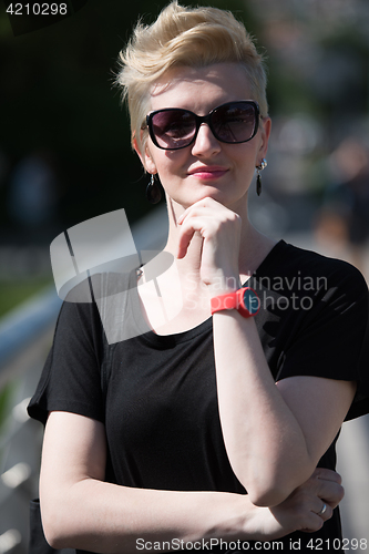 Image of young woman with short blond hair and sunglasses