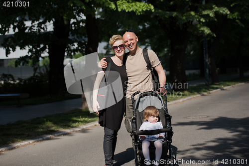 Image of couple with baby pram in summer park