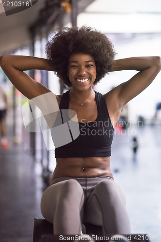 Image of black woman doing sit ups at the gym