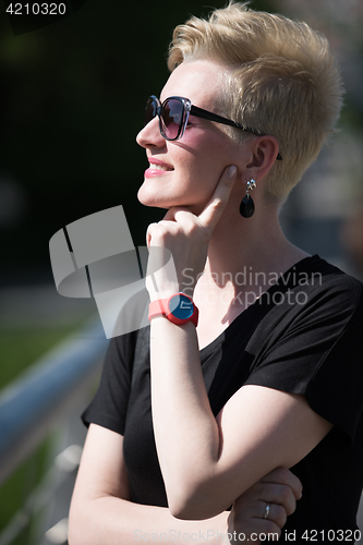 Image of young woman with short blond hair and sunglasses