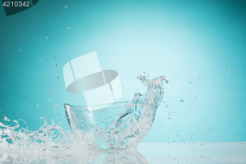 Image of The water splashing to glass bowl on white background