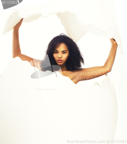 Image of young black skinned mulatto woman in big crashed egg isolated on white background, fashion people concept