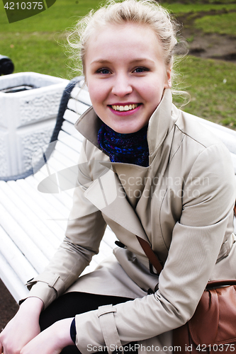 Image of young pretty blonde girl engoing spring nature in park, lifestyle epople concept