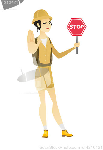 Image of Asian traveler holding stop road sign.