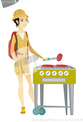 Image of Traveler woman cooking steak on barbecue grill.