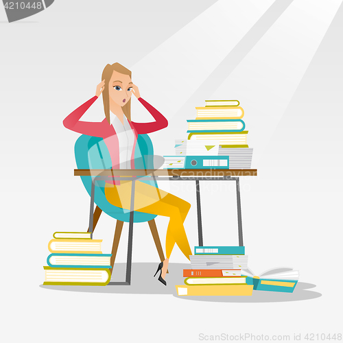 Image of Student sitting at the table with piles of books.