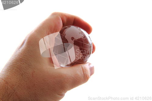 Image of glass earth globe in human hand