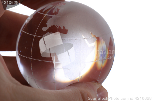 Image of glass earth globe in human hand