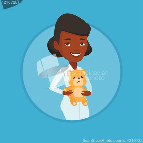 Image of Pediatrician doctor holding teddy bear.