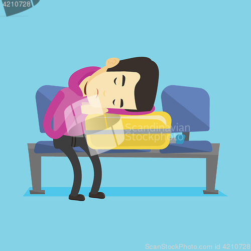 Image of Exhausted man sleeping on suitcase at airport.