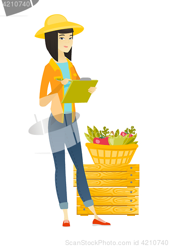 Image of Asian farmer writing on clipboard.