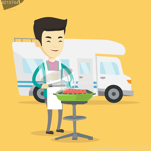 Image of Man having barbecue in front of camper van.