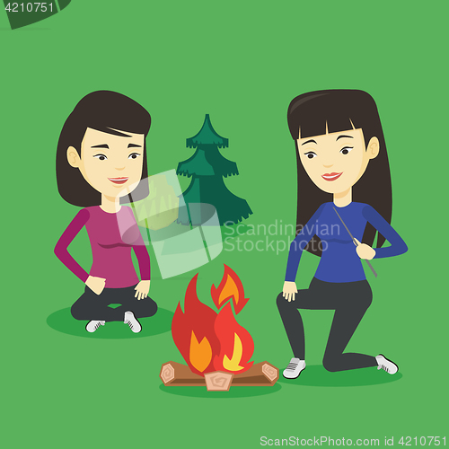 Image of Two friends sitting around bonfire in camping.