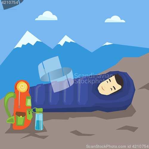 Image of Man sleeping in sleeping bag in the mountains.