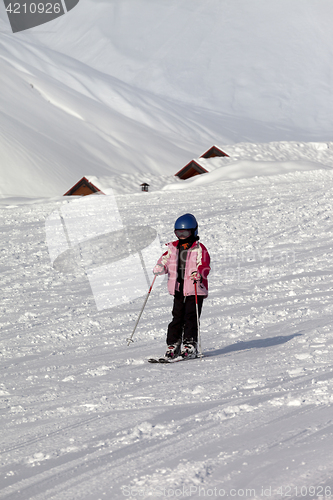Image of Little skier on ski slope at sun winter day