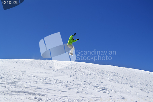 Image of Snowboarder jump in snow park at ski resort on sun day