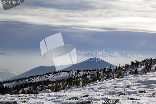 Image of Winter mountains and sunlight cloudy sky in haze