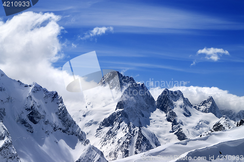 Image of Winter mountains with snow cornice and blue sky with clouds in n