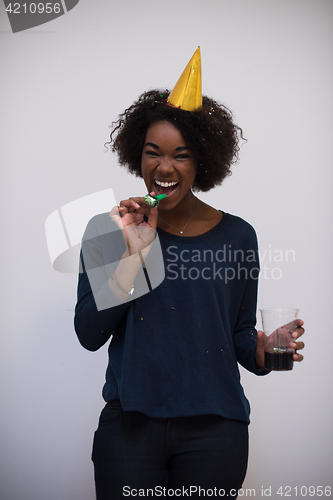 Image of black woman in party hat blowing in whistle