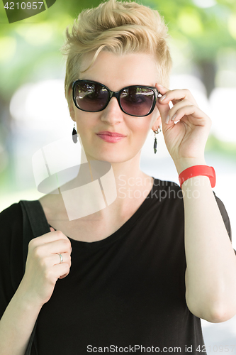 Image of young woman with short blond hair and sunglasses