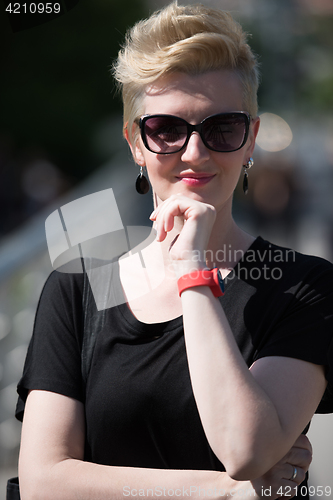 Image of young woman with short blond hair and sunglasses