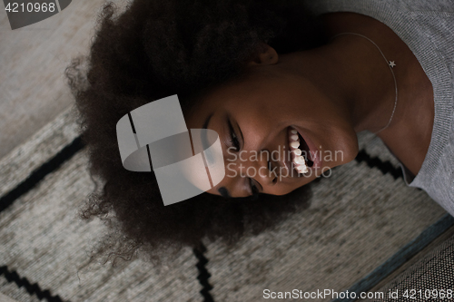 Image of black woman lying on carpet