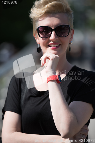 Image of young woman with short blond hair and sunglasses