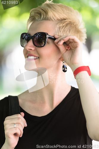 Image of young woman with short blond hair and sunglasses