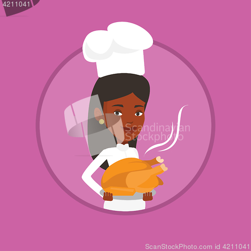 Image of Chef cook holding roasted chicken.