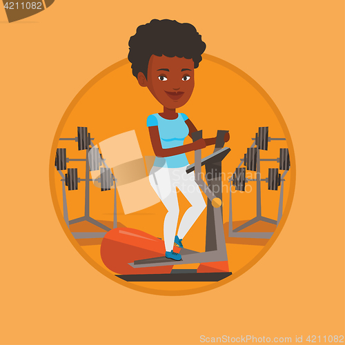 Image of Woman exercising on elliptical trainer.