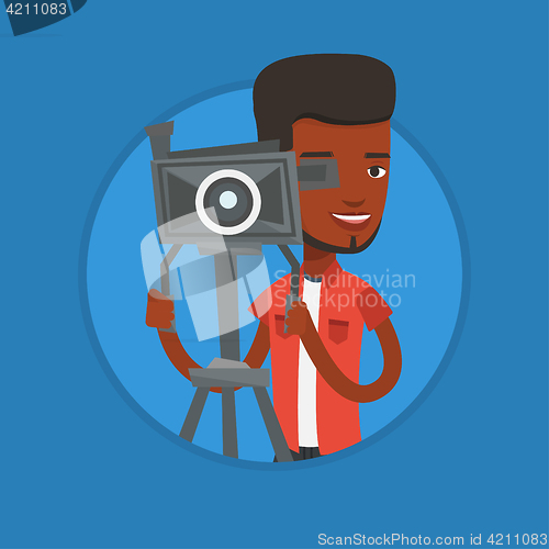 Image of Cameraman with movie camera on tripod.