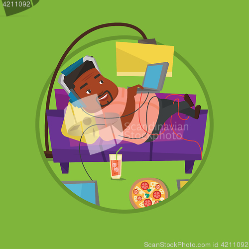 Image of Man lying on sofa with many gadgets.