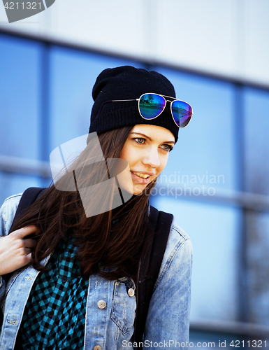 Image of young pretty girl near business building walking