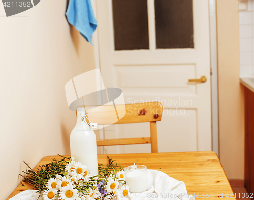 Image of Simply stylish wooden kitchen with bottle of milk and glass on t